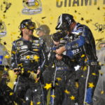 Jimmie Johnson popping the cork off of a champagne bottle