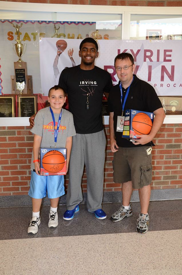 Tom Cavalli and son with Kyrie Irving with their autographed basketballs